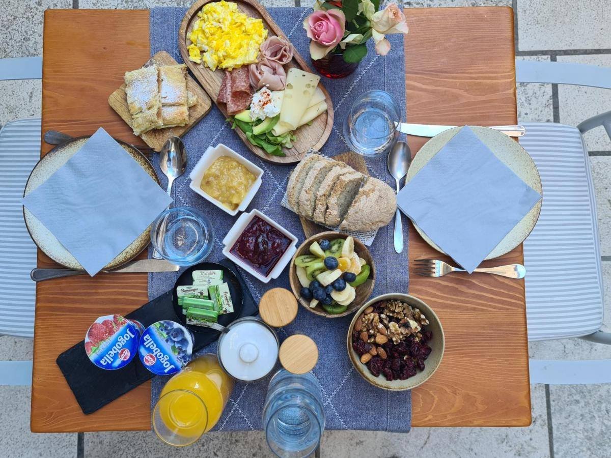 Villa Nora Hvar: a breakfast table with cold cuts, eggs, fruit, bread and juice