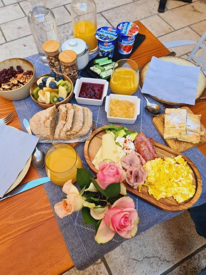 Villa Nora Hvar: breakfast served on a wooden table with juice, yogurt and fruit